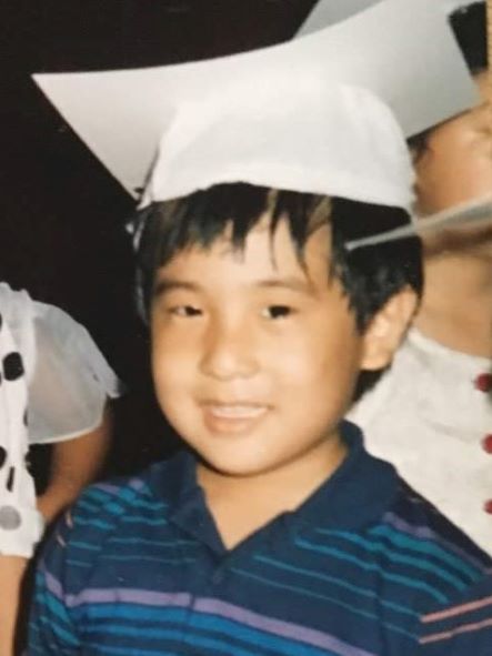 the author as a child wearing a white graduation cap